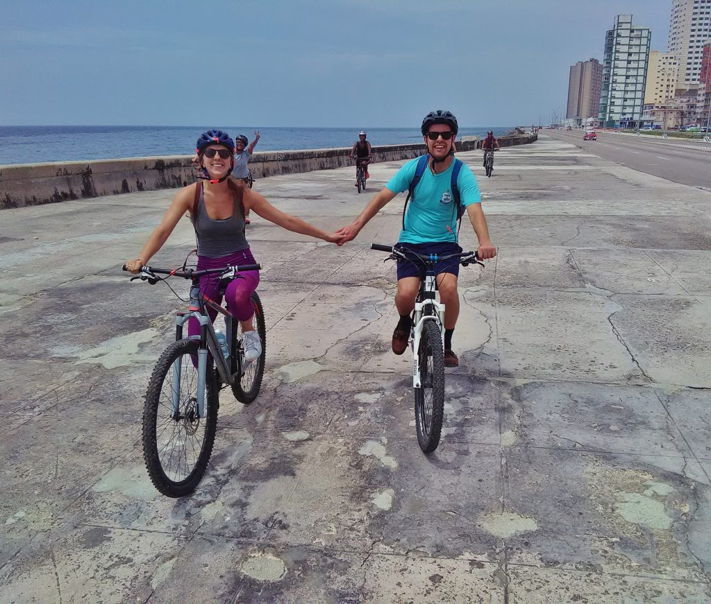 Brandon and Erin from Traveling Atlas biking on the Malecon in Havana, Cuba.